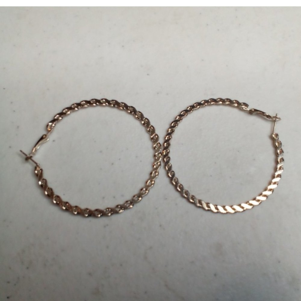 Silver stainless steel earings.intertwining detail snap backing size medium.
